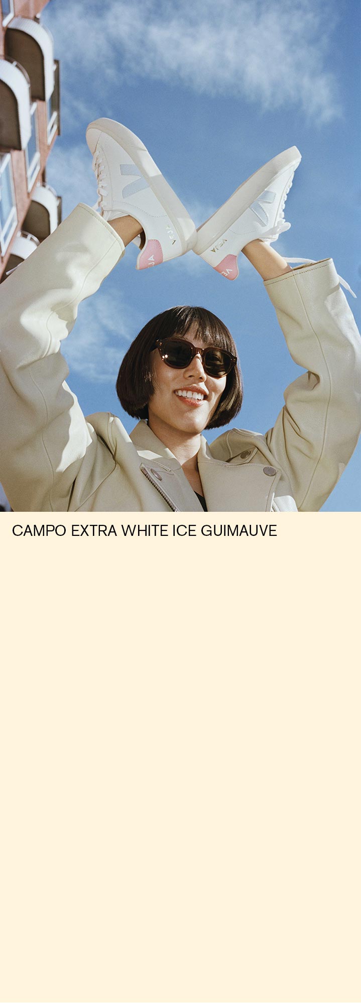 女人拿着veja campo extra white ice marshmallow trainers。
