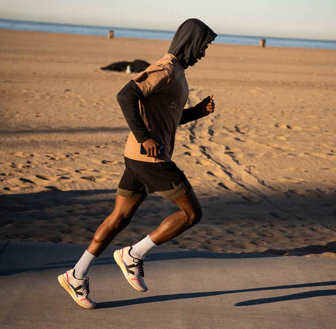 戴头巾的男子在海滩上奔跑